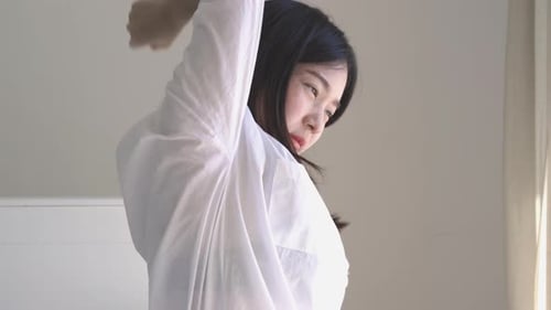Young Woman Stretching in Oversized White Shirt
