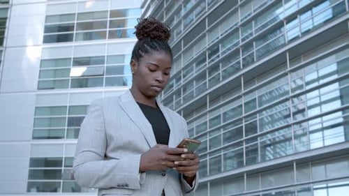 Woman Uses Mobile Phone in City Business District