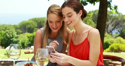 Two Women Friends Enjoying Lunch with Smartphone