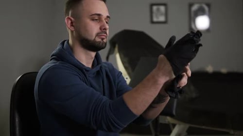 Man Putting on Protective Gloves in Studio
