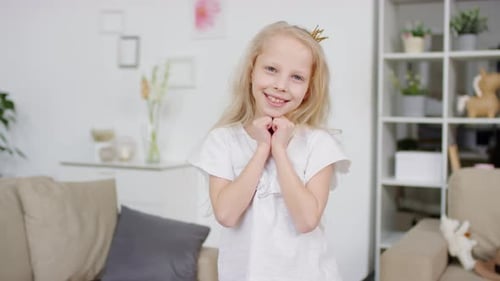 Smiling Girl in Crown Posing at Home