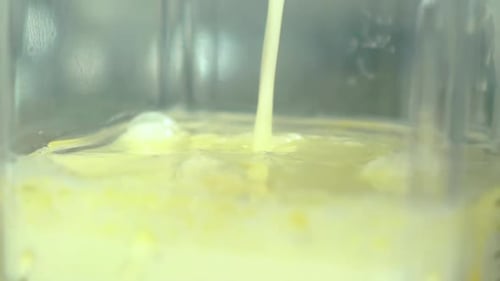 Yellow Liquid Pouring in Glass Container