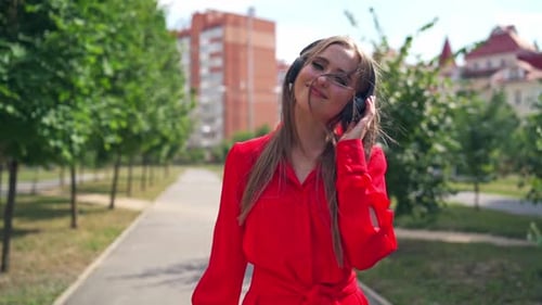 Young Woman Dancing With Headphones in City Park