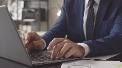 Adult Typing on Laptop in Office Environment