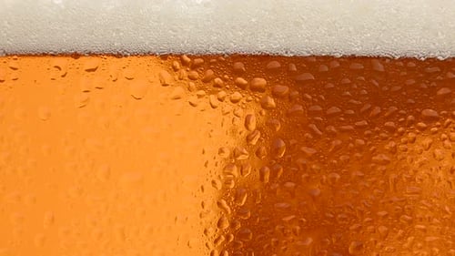 Close up background of beer with bubbles in glass