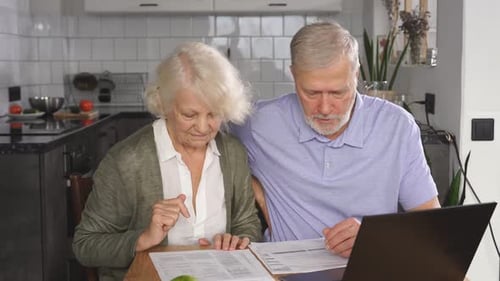 Mature Couple Reviews Financial Documents at Home