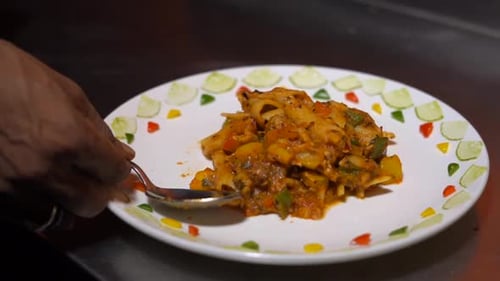 Serving Pasta with Spoon and Fork on Plate