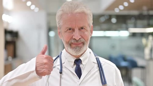 Senior Doctor Gives Thumbs Up in Clinic
