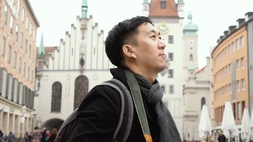 Young Asian Traveling Backpacker Taking Photos in City Centre in Europe