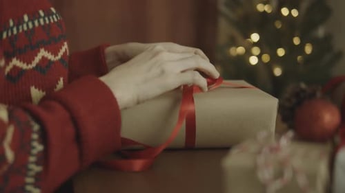 Wrapping Christmas Gifts with Red Ribbon and Christmas Tree