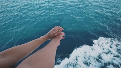 Manos de famale cruzadas sobre la vista del mar