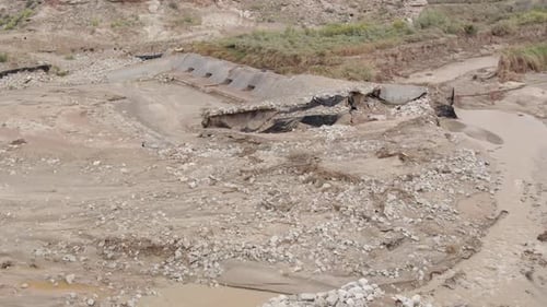 Panning view after flood from heavy rains washing out river banks