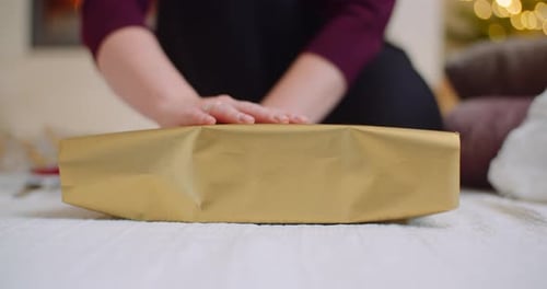 Woman Unwrapping Christmas Gift at Home