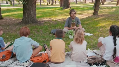 Man Teaching Curious Children in Park