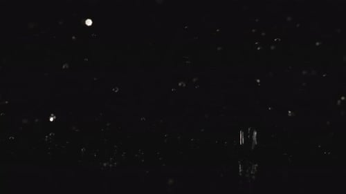 Water Droplets Splashing on Black Reflective Surface