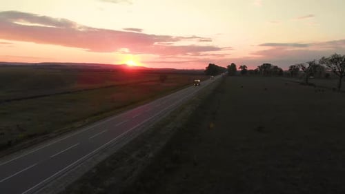 Aerial shot: vehicles, trucks and cars driving by road.