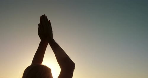 Woman doing yoga on the beach