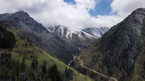 Aerial View of Green Valley and Snow-Capped Mountains