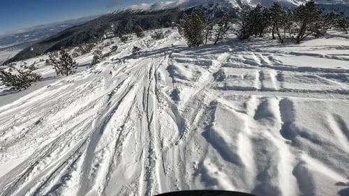 Man Snowboarding on a Ski Slope at a Mountain Resort on a Sunny Day