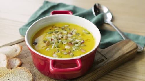 Bright Yellow Soup with Pumpkin Seeds Close-Up