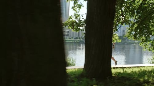 Female Athlete Running along Embankment