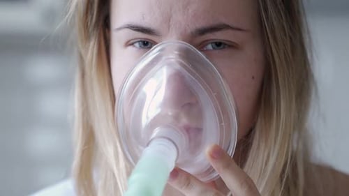 Woman Using Nebulizer Mask for Respiratory Treatment