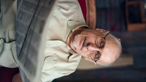 Senior Man Reading Newspaper Indoors Close Up