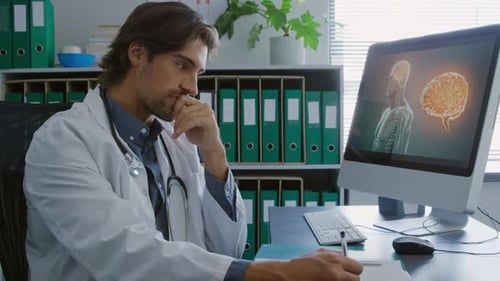 Doctor Working at Desk with Brain Scan on Computer