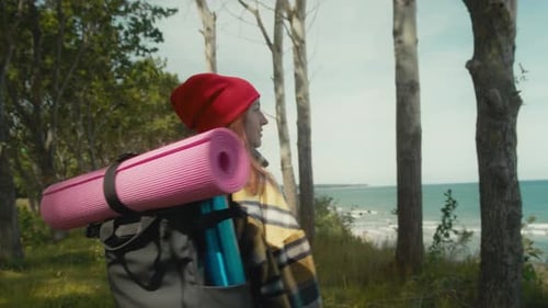 Woman Hikes With Yoga Mat Toward Ocean