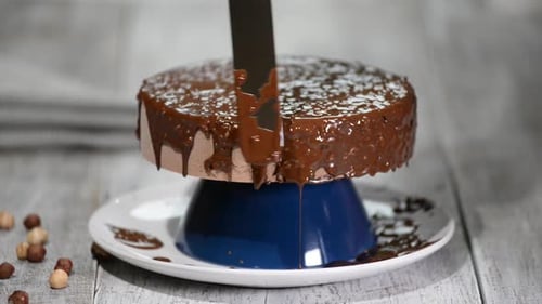 Chocolate Cake Being Decorated with Chocolate Sauce