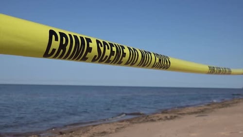 Crime Scene Tape on a Sandy Beach