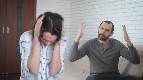 Woman Covers Ears During Argument with a Man