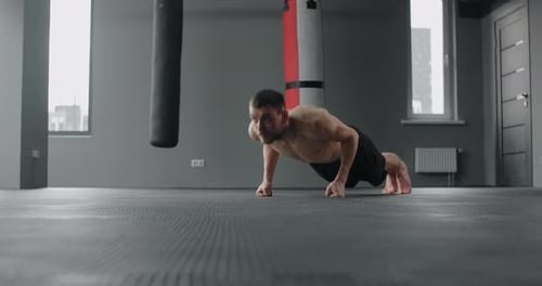 Athlete Performs Fast Pushups on His Fists at the Gym Camera Follows the Movement Workout Training