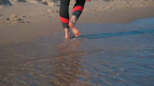 Bare Feet Walking on Beach at Water's Edge