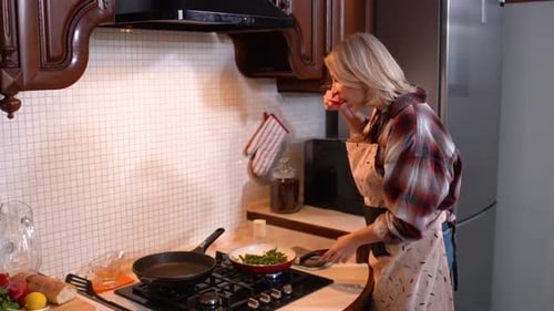 Woman Cooking Vegetables in Kitchen
