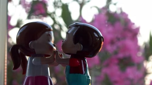 Toy Boy and Girl Holding Hands in Sunlight