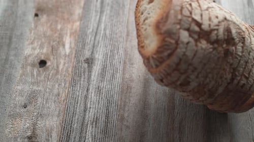 Sliced sourdough bread falling on a table. Slow Motion.