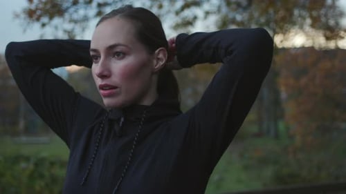 Woman Stretching Arms Before Exercise in Park