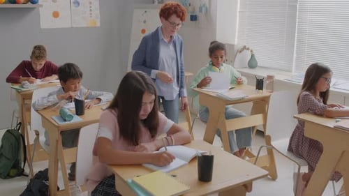 Students Working at Desks in Classroom with Teacher