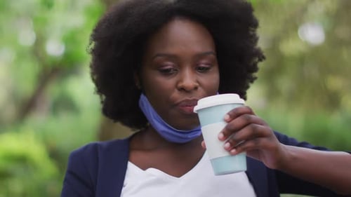 Mujer afroamericana con máscara facial en el parque