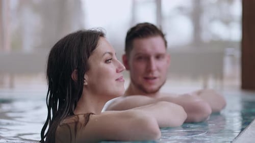 Adult Man and Woman are Resting in Modern Wellness Center Bathing in Swimming Pool