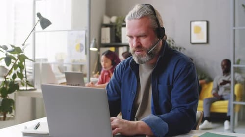 Portrait of Senior Call Center Agent in Headset at Work