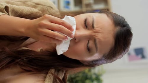 Woman Wipes Nose with Tissue, Uses Nasal Spray