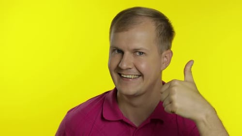 Man Gives a Thumbs Up on Yellow Background