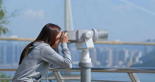 Tourist look at the binocular for seeing the view in Hong Kong