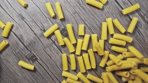 the Spaghetti Crumbles and Falls on the Wood Table. Slow Motion