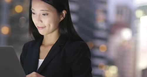 Businesswoman Works on Tablet at Night
