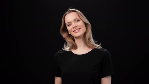 Woman Smiling in Front of Black Background