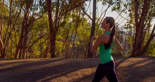 Woman Running Through Forest in Sunlight