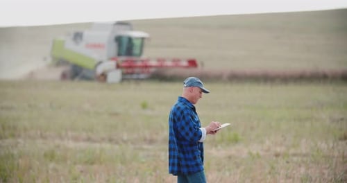 Farmer Using Digital Tablet While Examining Field